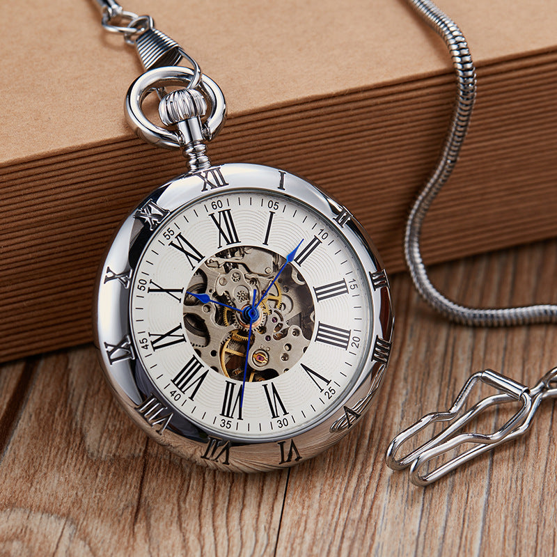 Silver pocket watch with Roman numerals on a wooden surface