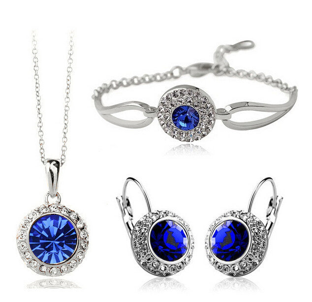 Jewelry set with blue gemstones including necklace, earrings, and bracelet on a white background