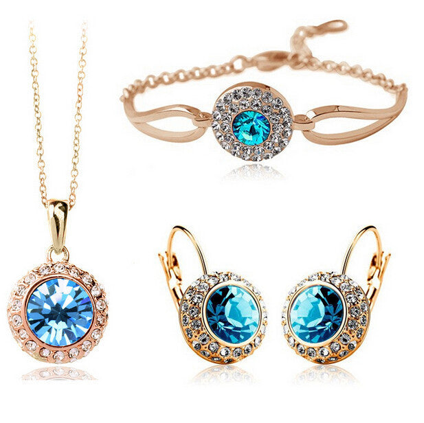 Jewelry set with blue gemstones including necklace, bracelet, and earrings on a white background