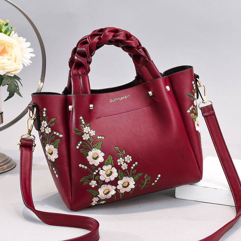 Red handbag with floral embroidery on a light background