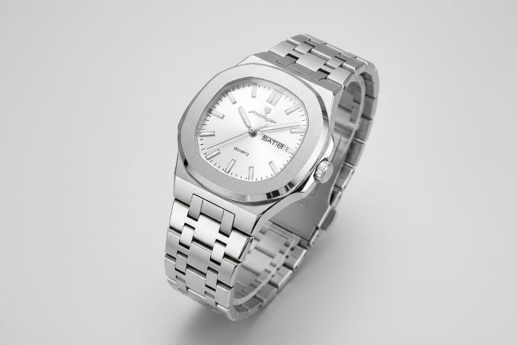 Silver wristwatch with a visible brand tag on a beige background