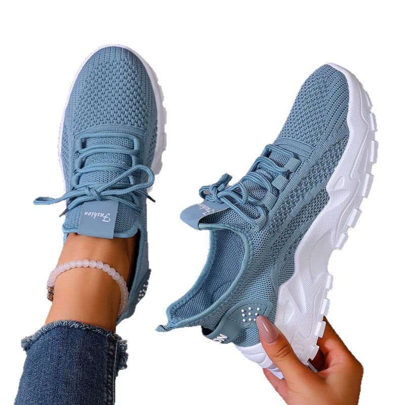 Blue knit lace-up women's sneakers with white outsole, side and heel view
