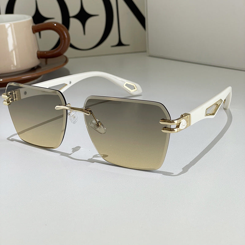Gold sunglasses with gradient lenses on a light surface, with a blurred background