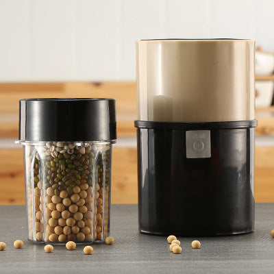 Kitchen grinder with a jar of beans on a wooden surface