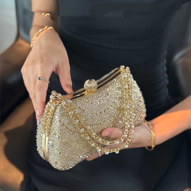 Gold rhinestone clutch handbag with gold-tone chain strap and kisslock metal frame.