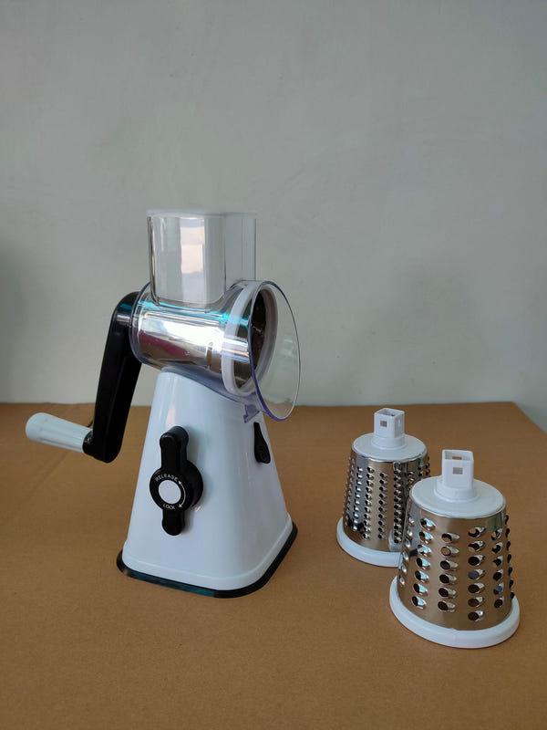 White vegetable cutter slicer with clear hopper and rotary grater attachments