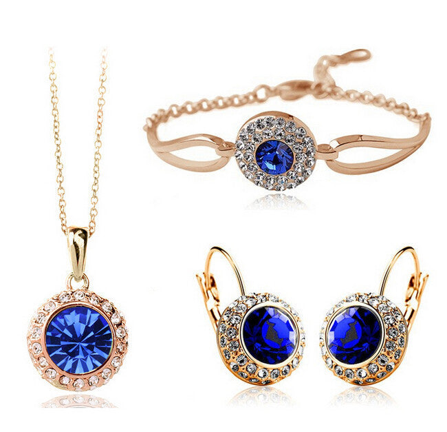 Jewelry set with blue gemstones including necklace, earrings, and bracelet on a white background