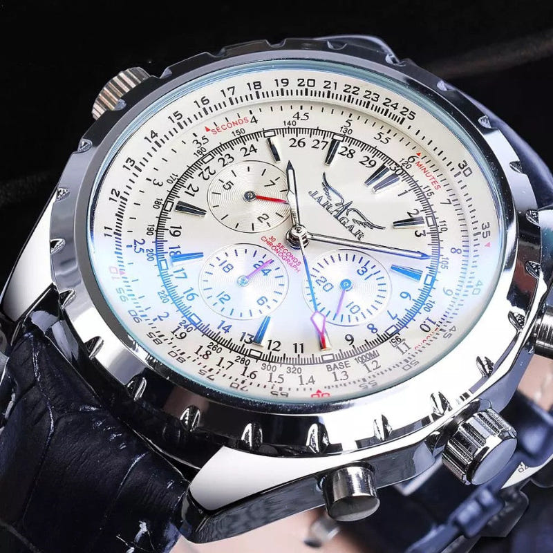 Mechanical automatic watch close-up with white dial, blue markings, silver case, black strap