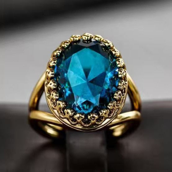 Gold ring with a blue gemstone on a dark background