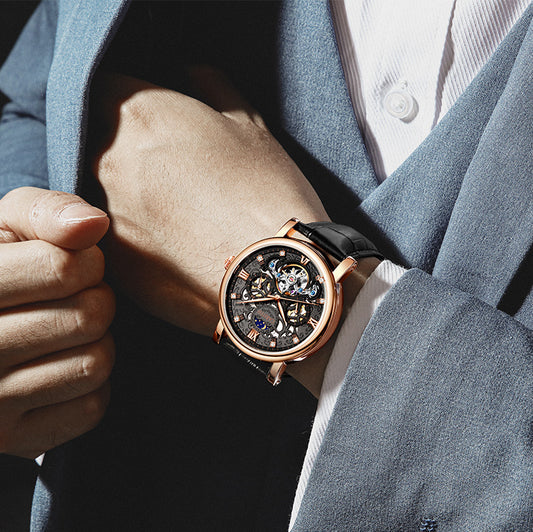 Close-up of a person wearing a rose gold watch with a dark face.