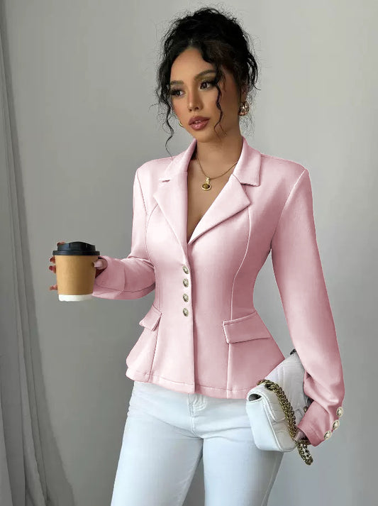 Woman wearing a pink blazer holding a coffee cup against a plain background