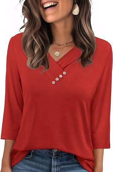 Woman wearing a red blouse with buttons and blue jeans, smiling.