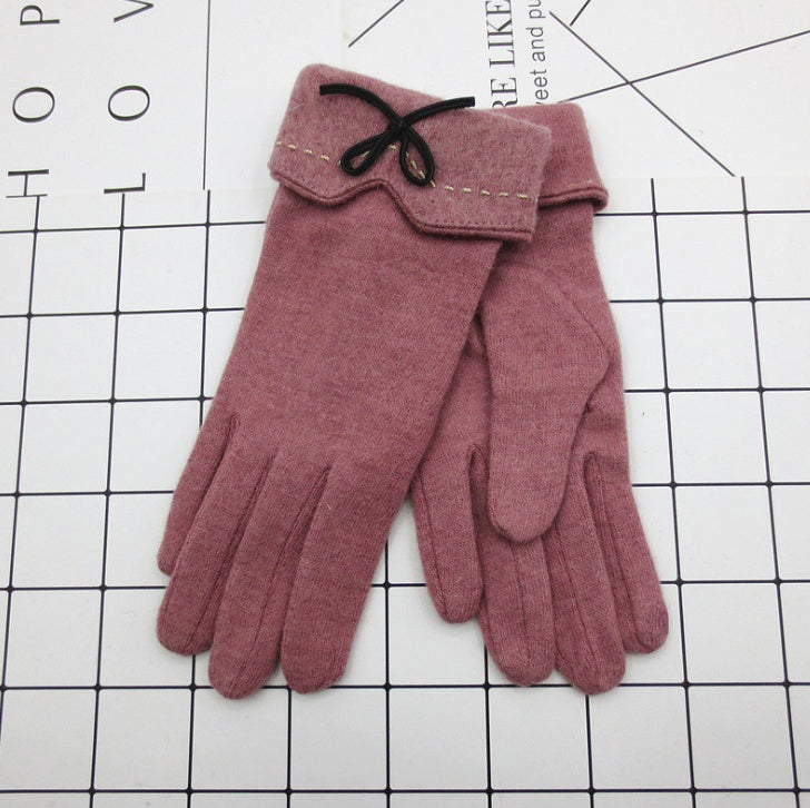 Mauve winter gloves with stitched cuff flap and black bow at the wrist