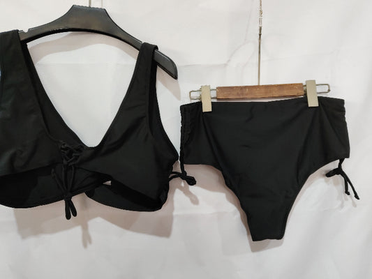 Black bikini set on hangers against a white background