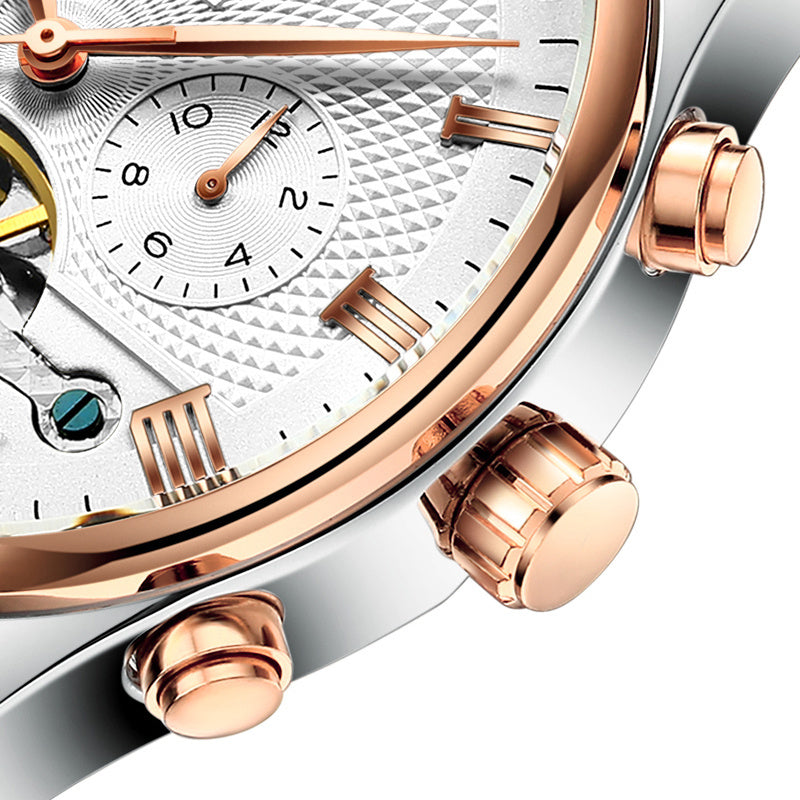 Close-up of a luxury watch with rose gold and silver accents on a white background