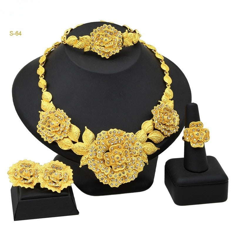 Gold floral jewelry set on a black stand with 'S-64' label.