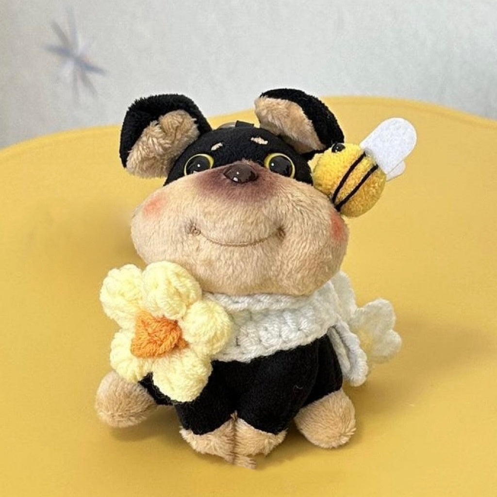 Plush toy dog with a bee and flower on a yellow surface