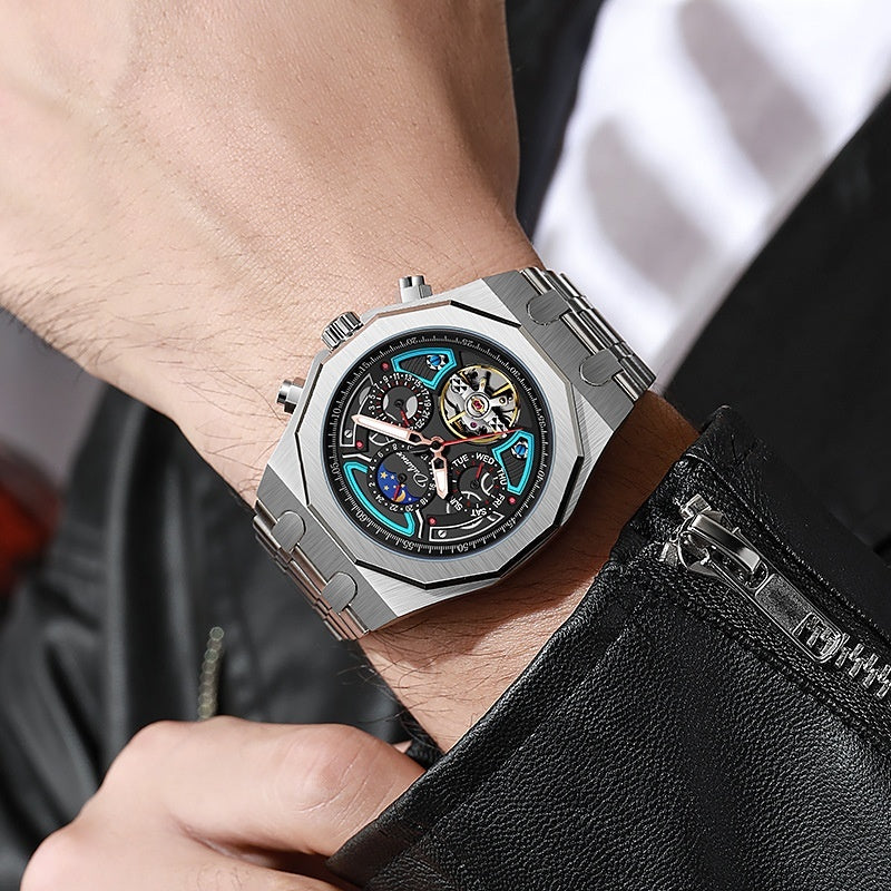Silver wristwatch with blue accents on a person's wrist, wearing a black leather jacket.