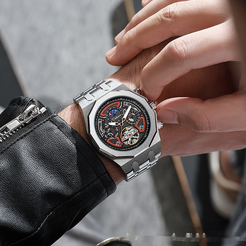 Close-up of a person wearing a silver wristwatch with a detailed face.