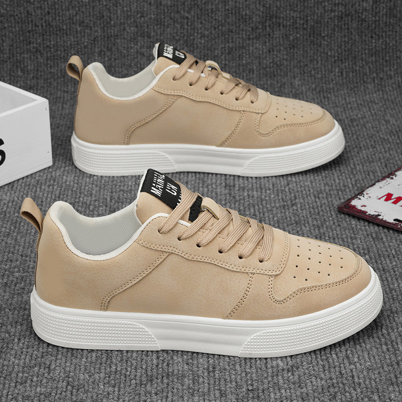 Beige sneakers with white soles on a gray textured surface