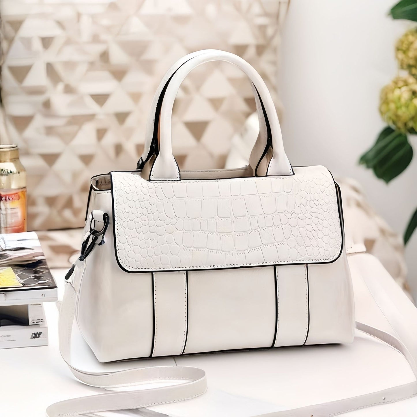 White handbag with black accents on a surface with a blurred background