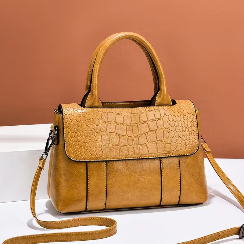 Brown handbag with a textured pattern on a white surface with a brown background