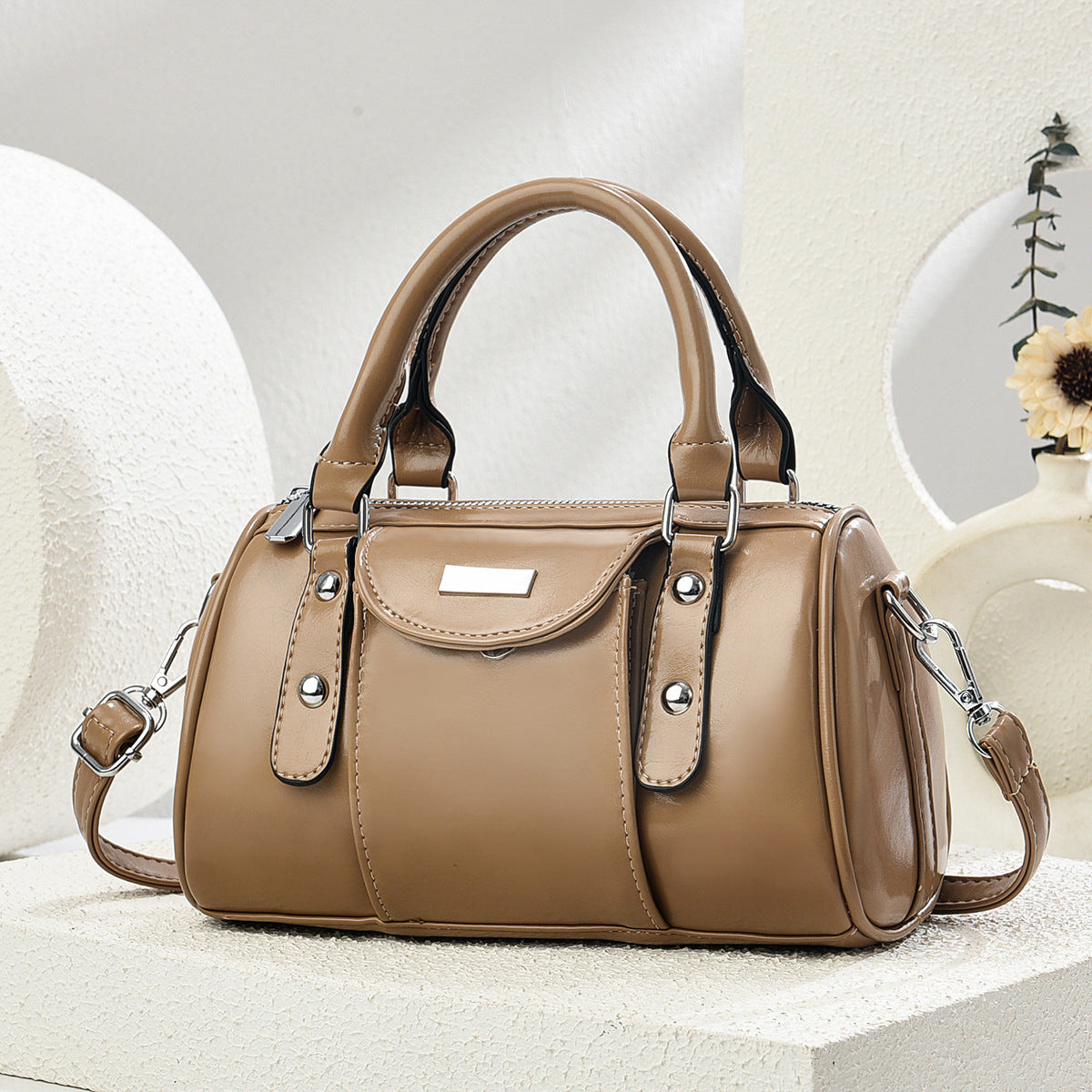 Brown handbag with silver accents on a light background