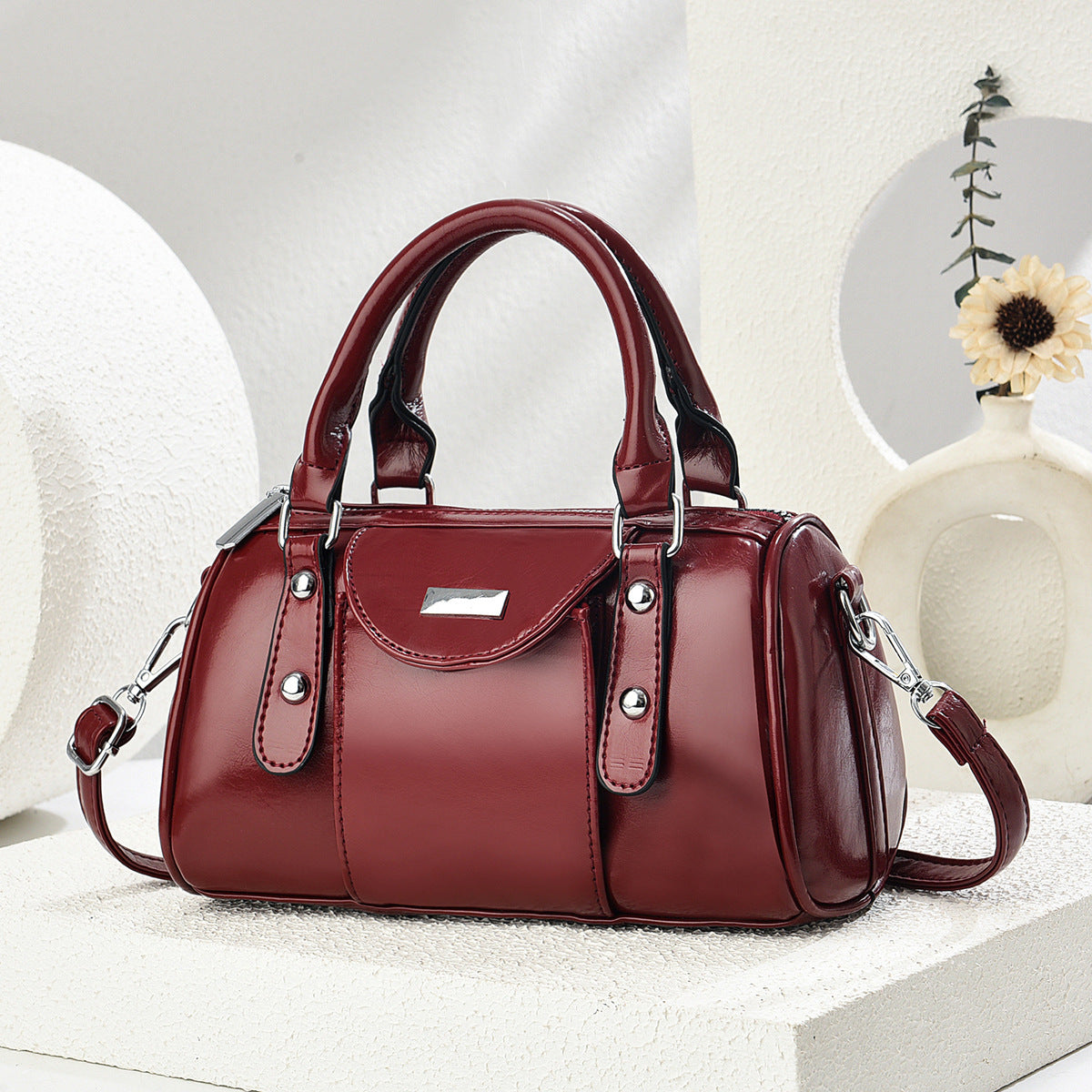 Red handbag on a white surface with a neutral background