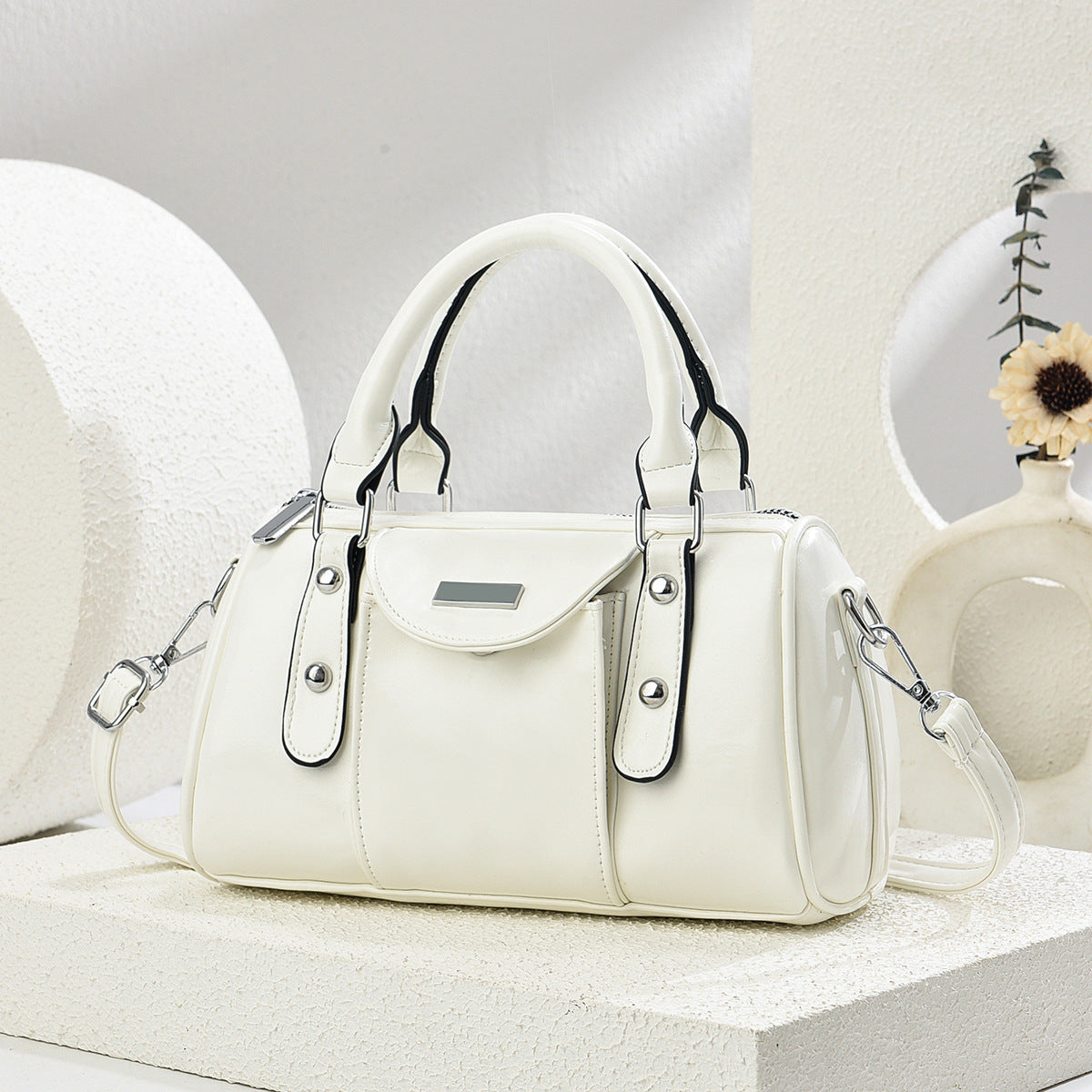 White handbag with black accents on a light gray background