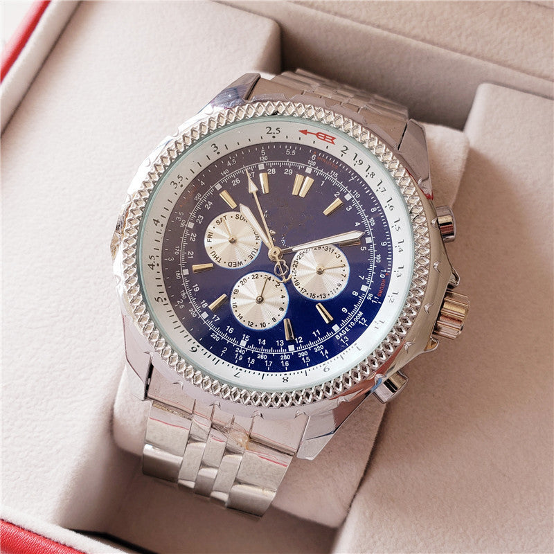 Luxury watch with a blue face and silver case on a beige cushion