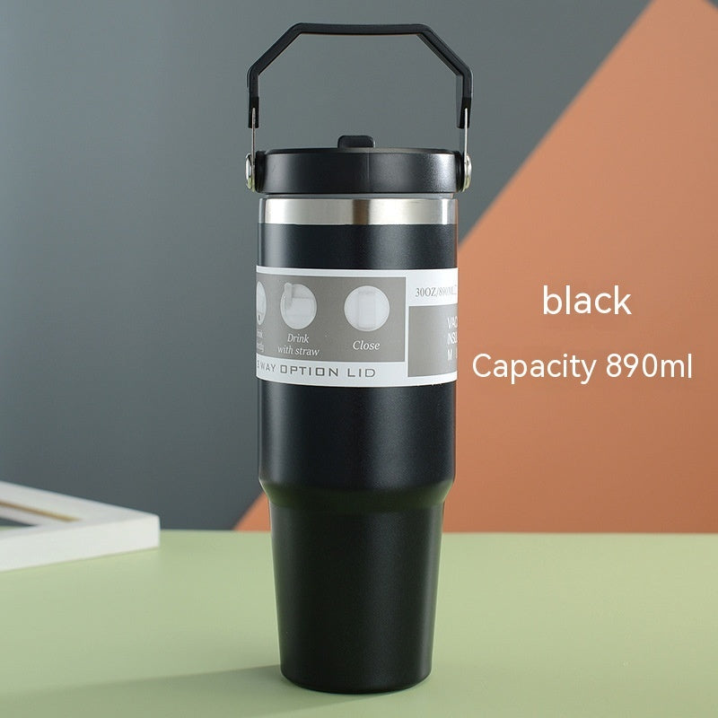 Black insulated travel mug with handle on a colorful background