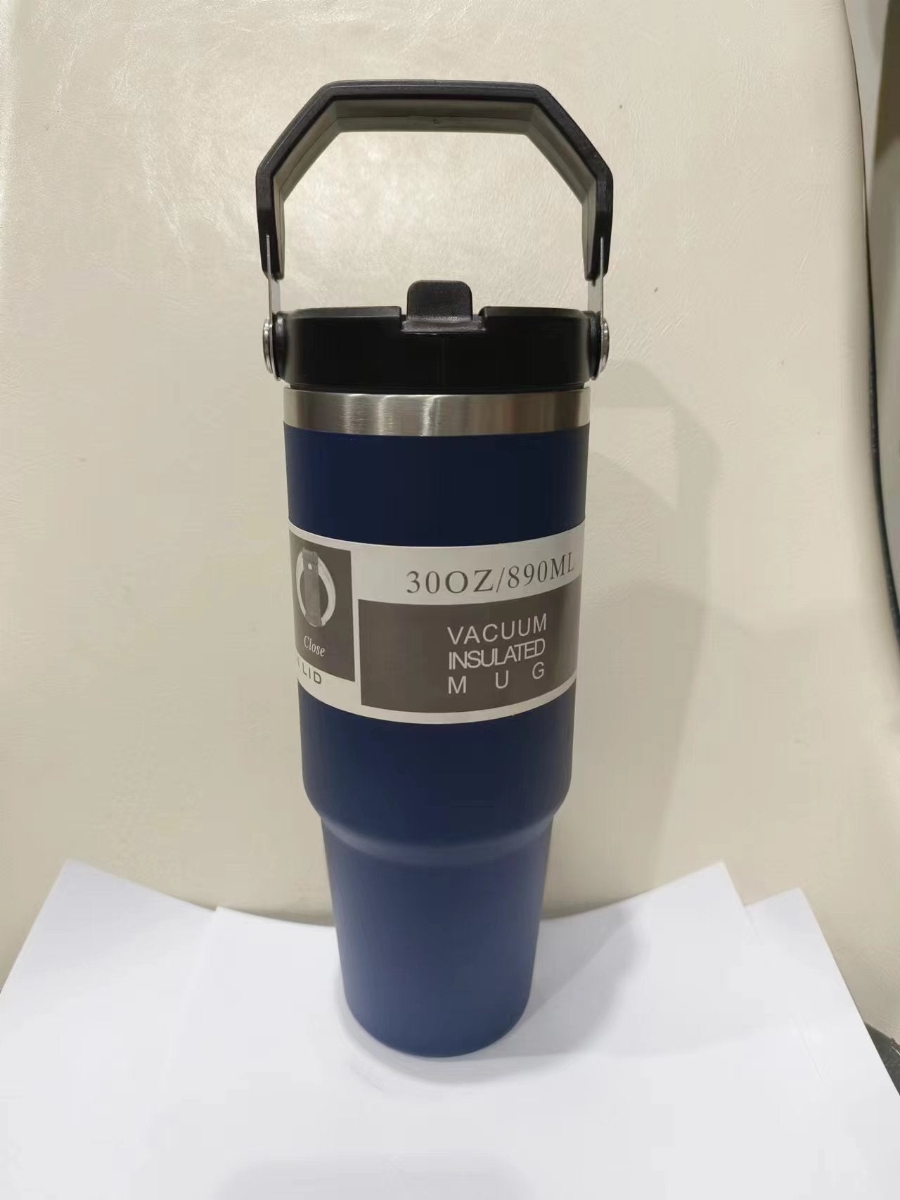 Blue vacuum insulated mug with a label on a white surface