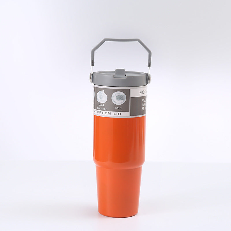 Orange insulated tumbler with gray lid on a white background