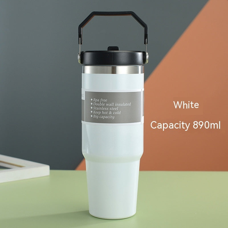 White insulated tumbler with black handle on a colorful background