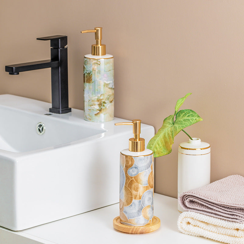 Bathroom setting with marble-patterned soap dispensers, sink, and towel on a beige background