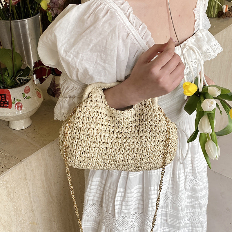 Person holding a woven handbag with a blurred background
