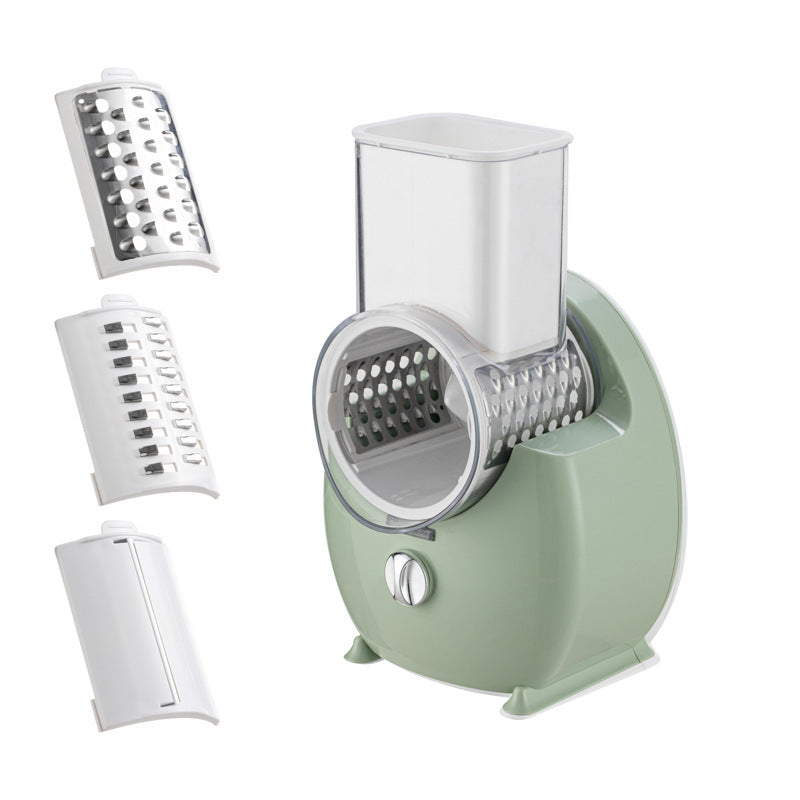 Green and white electric slicer and grater with blade attachments and tall transparent feeder cup