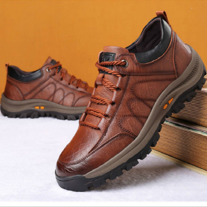 Brown leather shoes with orange laces on a white surface with an orange background