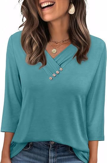 Woman wearing a teal blouse with buttons and jeans, smiling.