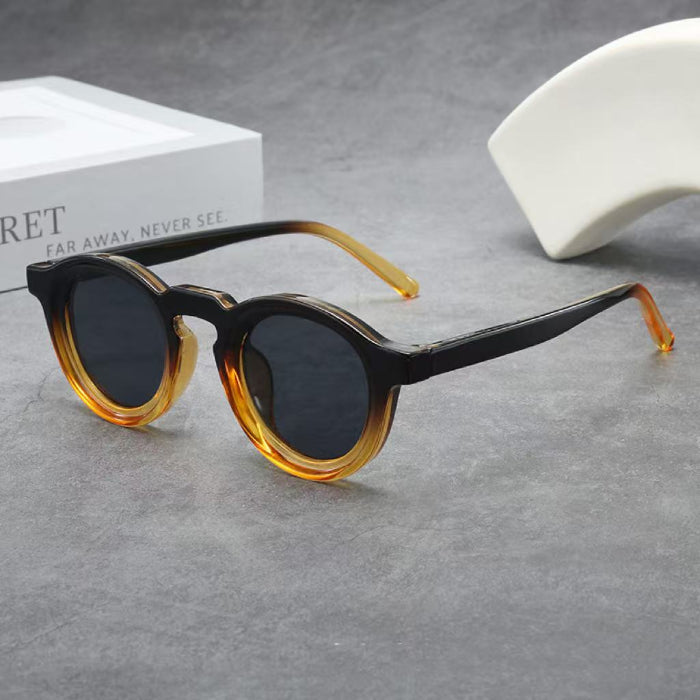 Sunglasses with tortoiseshell frame and dark lenses on a gray surface