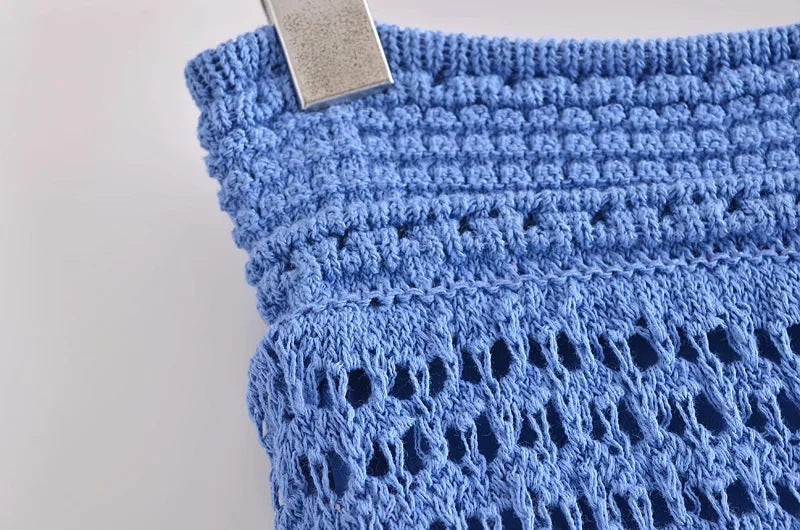 Close-up of blue crochet fabric with a white background