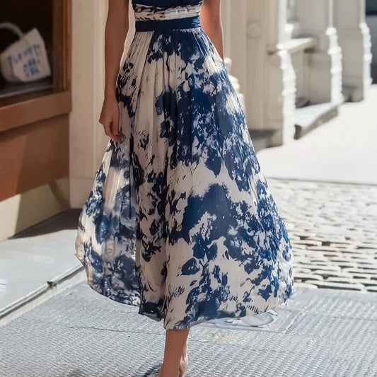 Woman wearing a blue and white floral dress on a street.