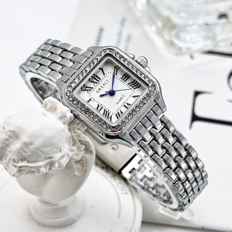 Silver watch with diamond accents on a white surface