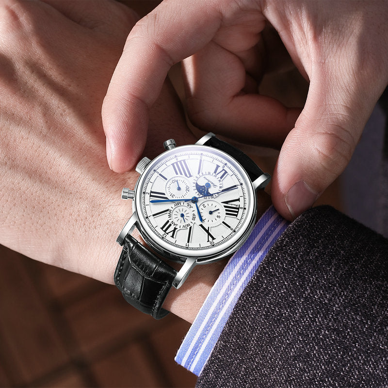 Mechanical multifunction watch with silver case, white dial with blue subdials, and black leather strap.