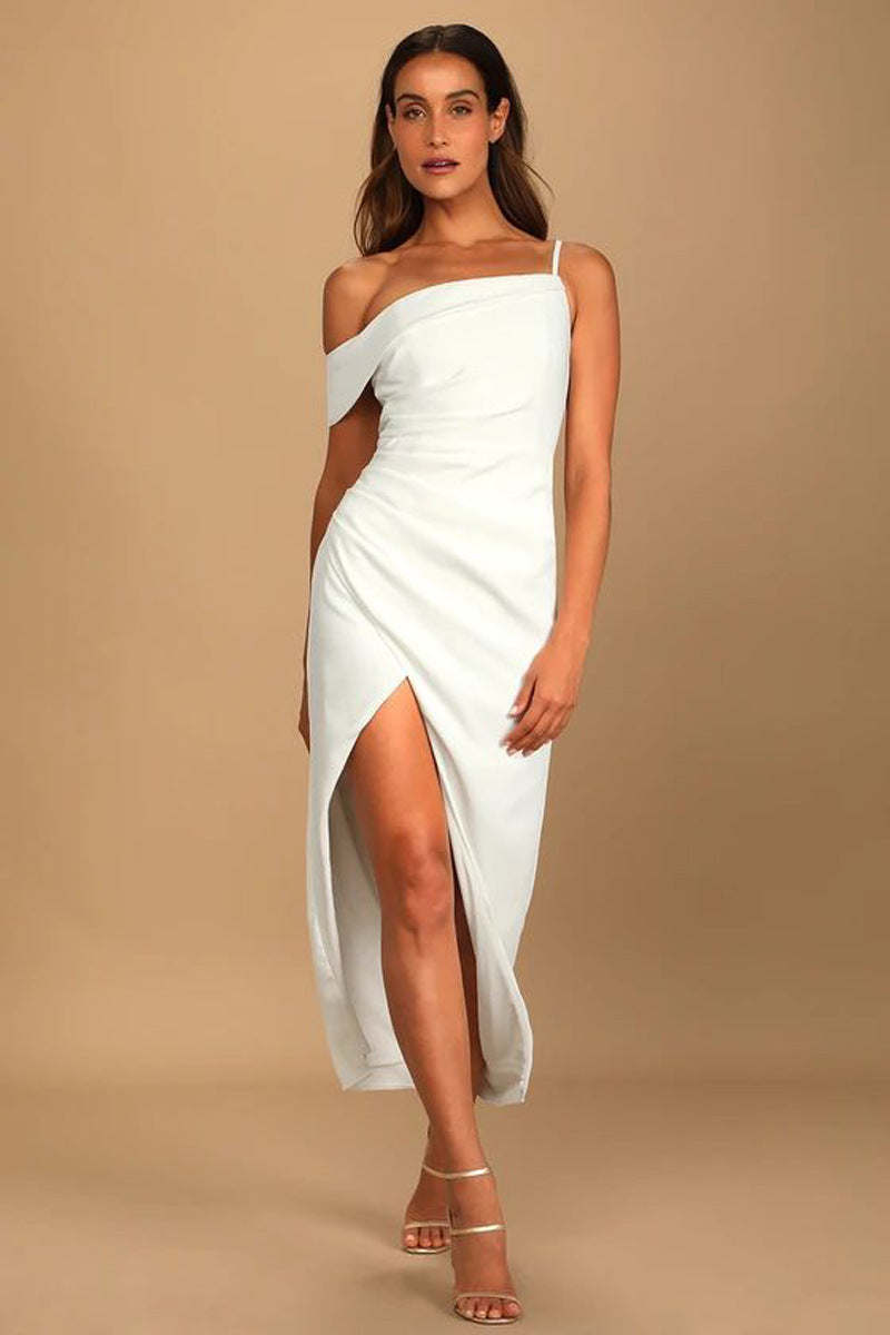 Woman wearing a white one-shoulder dress with a slit on a beige background