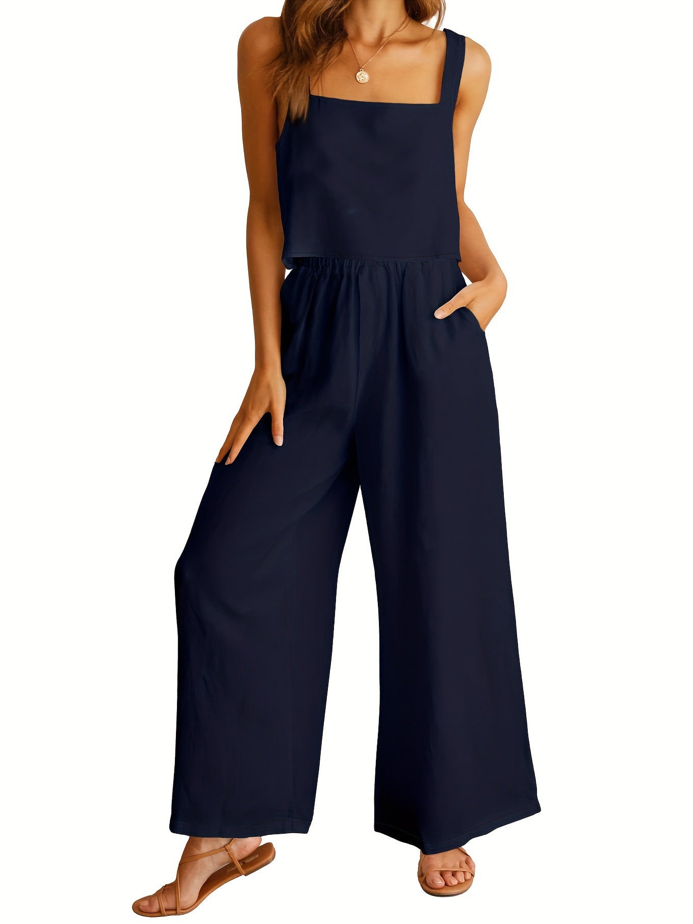 Navy blue jumpsuit worn by a model on a white background