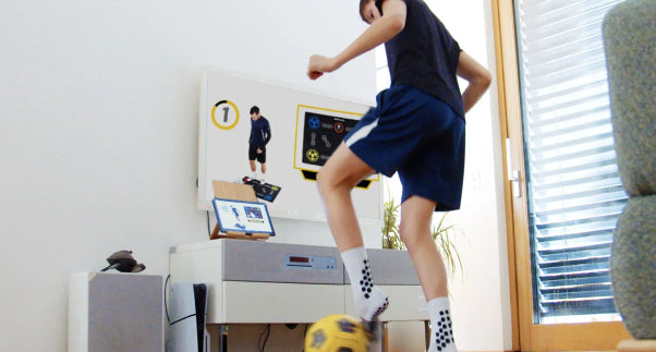 Soccer training mat with numbered targets and ball graphics under a player