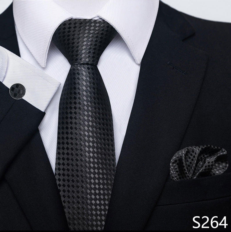 Black patterned tie with matching pocket square on a suit, brand 'S264' visible.