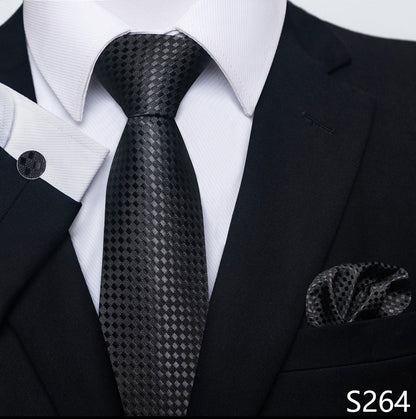 Black patterned tie with matching pocket square on a suit, brand 'S264' visible.