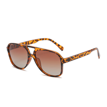 Sunglasses with leopard print frame and brown gradient lenses on a white background